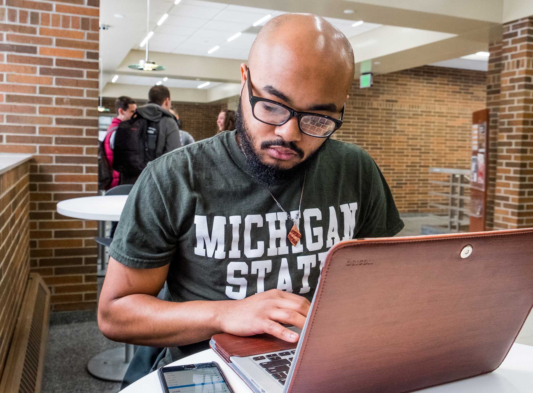 Student working on a laptop in a common area